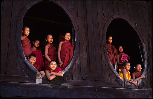 Les garçons dans une robe de moine rouge foncé se tenait près des portes ovales.